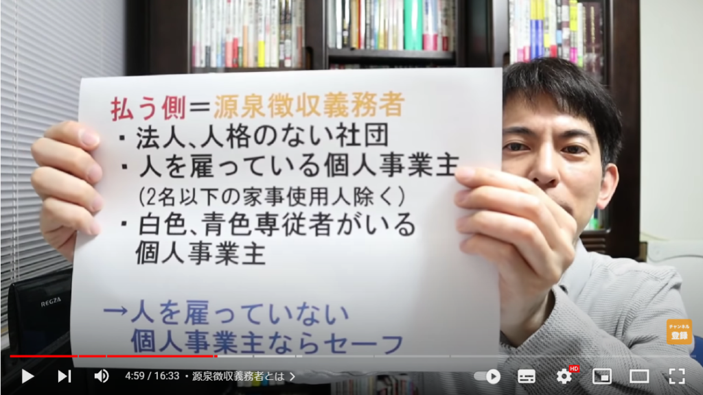 山田さんが源泉徴収義務者について解説している場面。手には源泉徴収義務者の解説が書かれた紙を持っている。