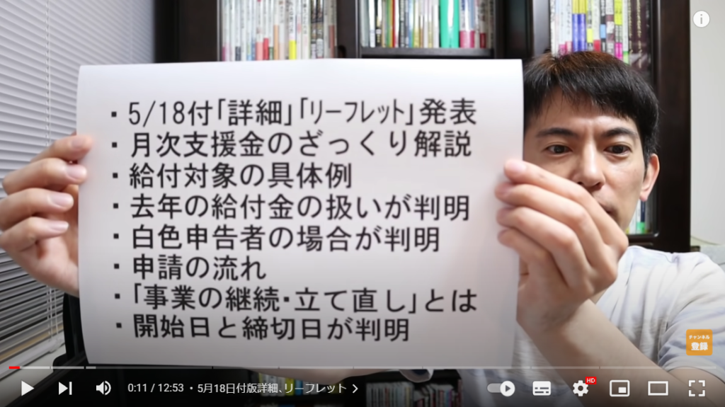 山田さんがこの動画の概要について解説している場面。手には、概要が書かれた紙を持っている。