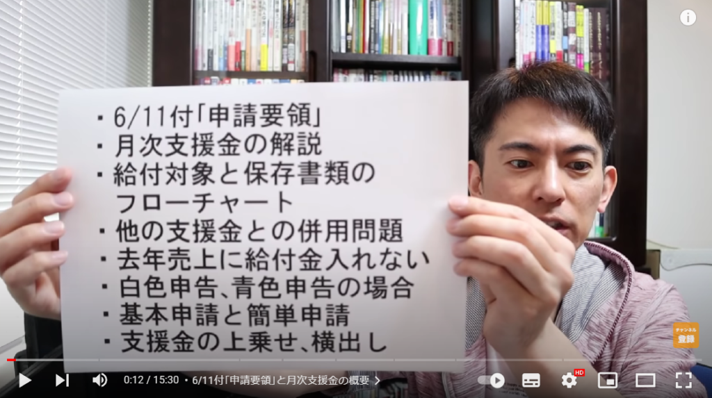 動画の概要について解説している場面。山田さんは、概要について書かれた紙を持っている。