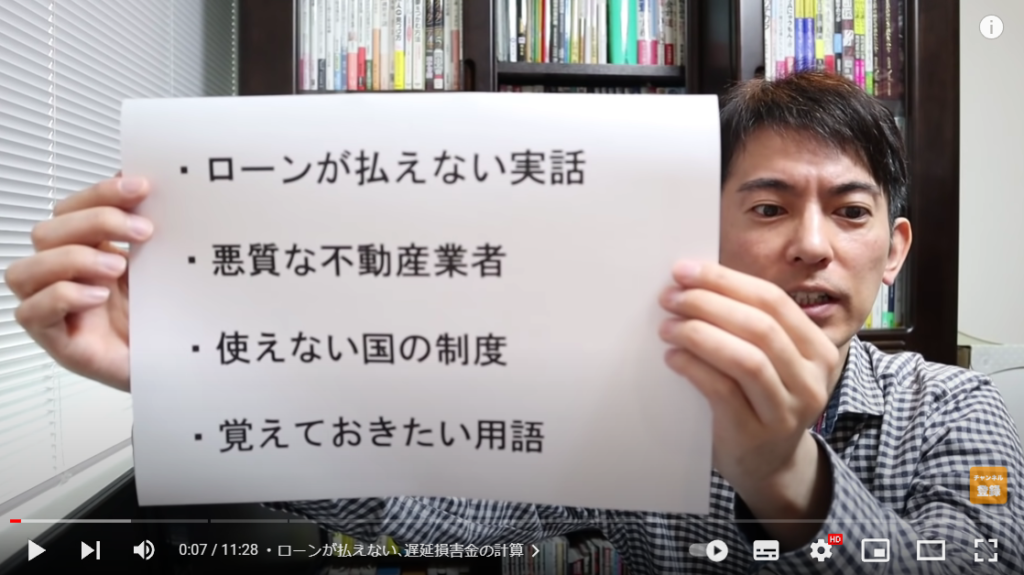 山田さんが動画の概要について解説している場面。手には概要が書かれた紙を持っている。