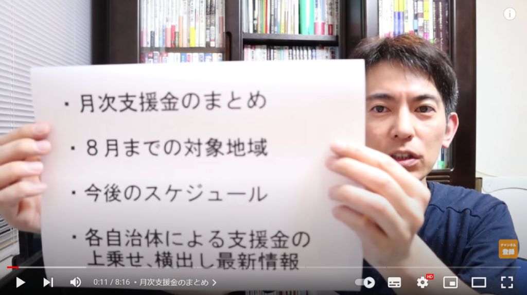 山田さんが動画の概要について解説してる場面。手には、概要が書かれた紙を持っている。