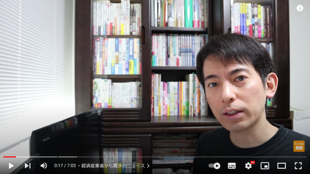 経済産業省からの驚きの発表にてついて解説している場面。山田さんが本棚の前に座っている様子。