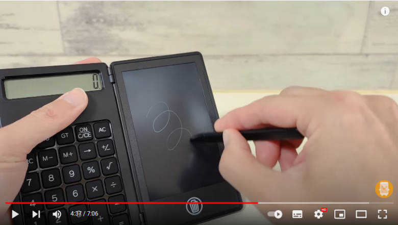 左側の電卓には0と書いてあり、右側の電子メモには専用のペンを使ってくるくる線を書いています。電子メモの使用感などを説明している場面です。