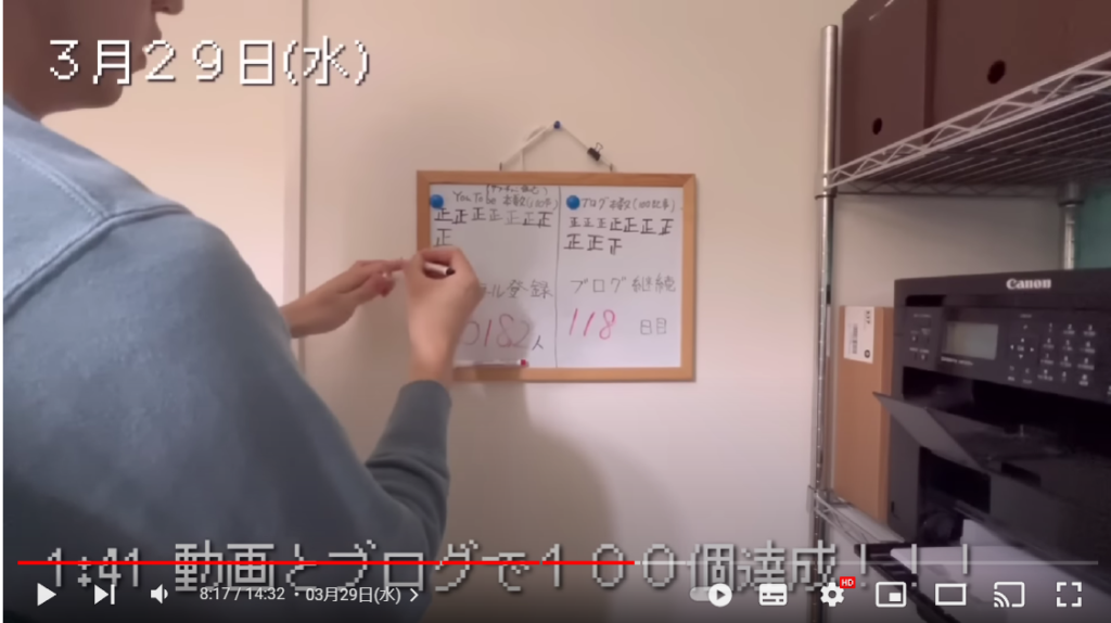 TAKAHIROさんが、ホワイトボードに登録者数を記入している場面。