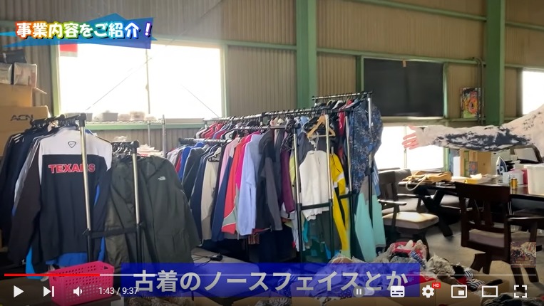 倉庫の中を紹介している様子。画面には仕入た古着の服がハンガーラックにかかっている様子が映し出されている。
