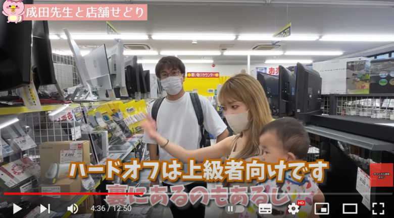 店舗で商品を見る男性と子供を抱っこした女性の様子