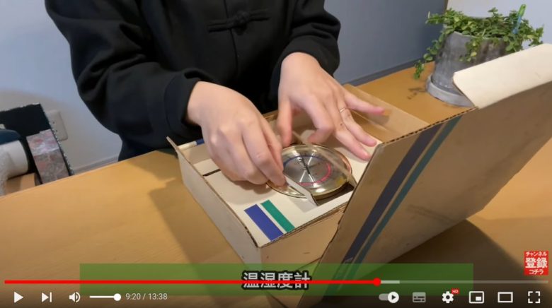 作業台でmidoriさんが、メルカリで売れた｢温室時計｣を箱から出そうとしている様子が映っています。