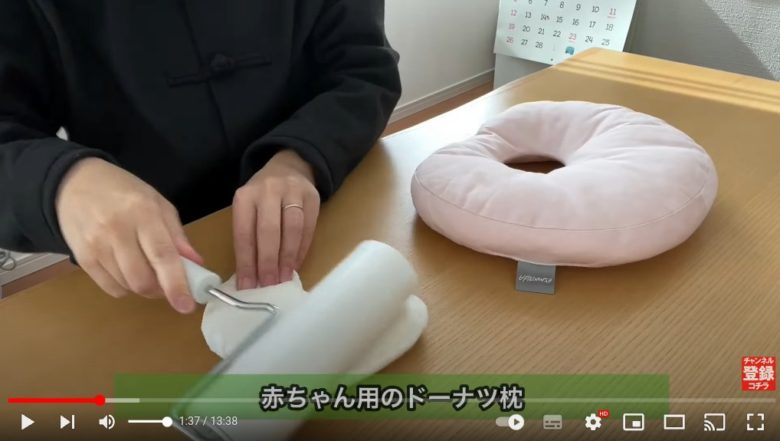 作業台でmidoriさんが、メルカリで売れた｢赤ちゃん用のドーナツ枕｣を粘着カーペットクリーナーを使ってきれいにしている様子が映っています。